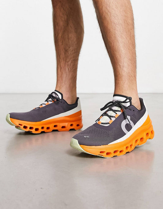 On Running Cloudmonster trainers in grey and orange